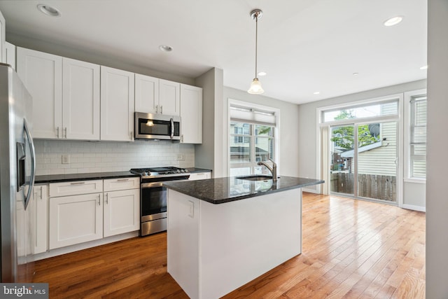 1256 S 27th St, Philadelphia, PA 19146 - kitchen featuring tasteful backsplash, white cabinets, appliances with stainless steel finishes, and wood finished floors