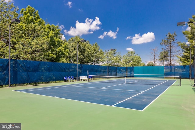 view of tennis court with fence and community basketball court