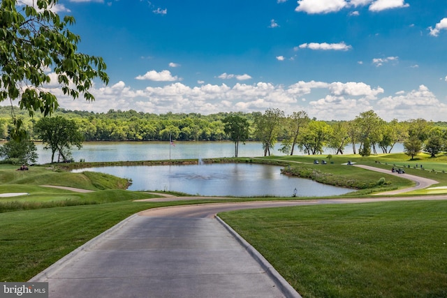 surrounding community with a yard, a water view, and view of golf course