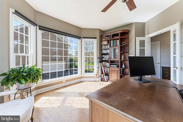office space featuring baseboards, a ceiling fan, and wood finished floors