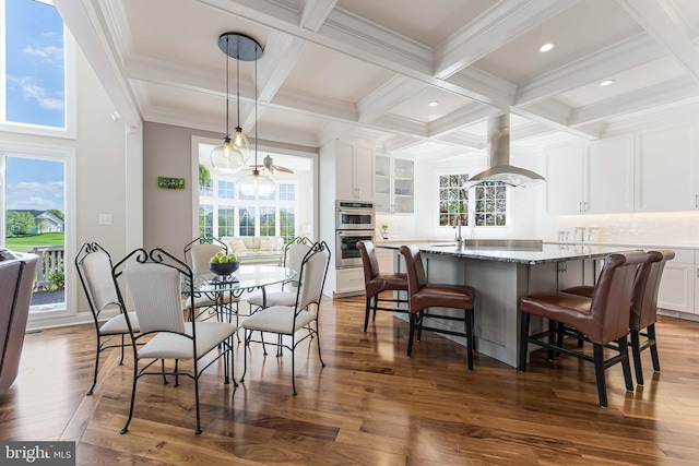 dining area with a wealth of natural light, beam ceiling, and dark wood finished floors
