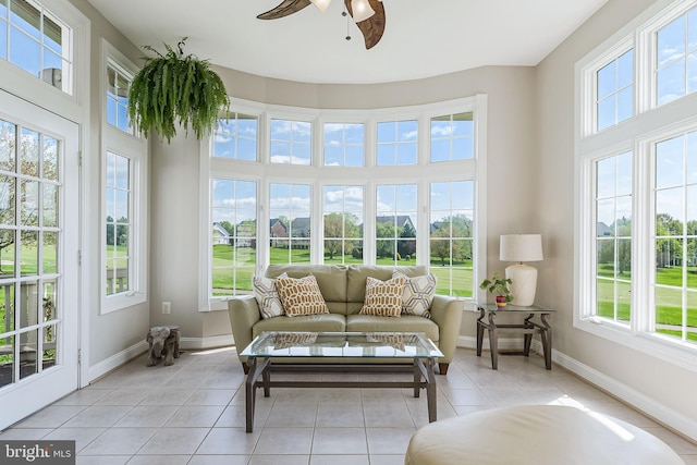 sunroom / solarium featuring a wealth of natural light, tile patterned floors, and baseboards