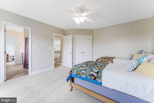 bedroom featuring baseboards, a ceiling fan, light carpet, and a closet
