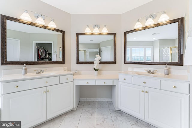 bathroom with marble finish floor, a sink, and two vanities