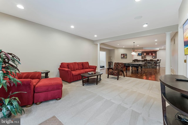 carpeted living room featuring decorative columns, wood finished floors, and recessed lighting