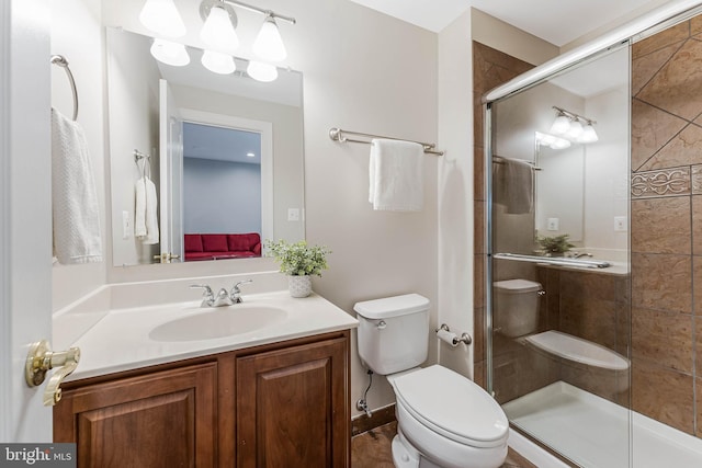 full bathroom with toilet, vanity, and a shower stall