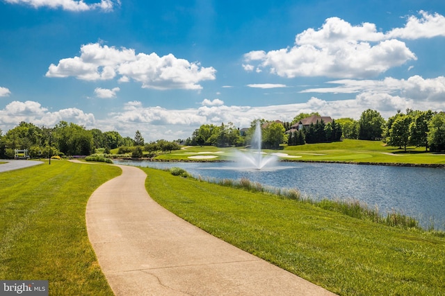 view of home's community with a yard, golf course view, and a water view