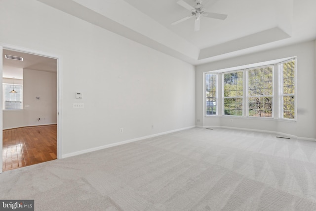 unfurnished room featuring carpet, visible vents, baseboards, and a ceiling fan