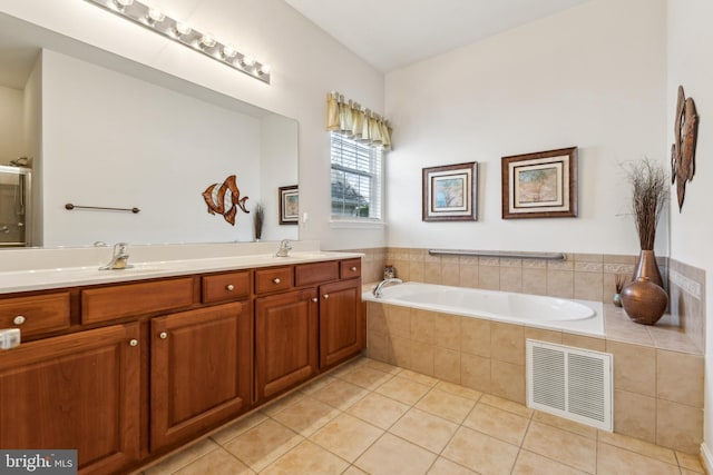 bathroom featuring a garden tub, tile patterned flooring, visible vents, a sink, and double vanity