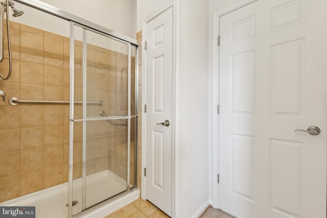 bathroom with a shower stall and tile patterned flooring