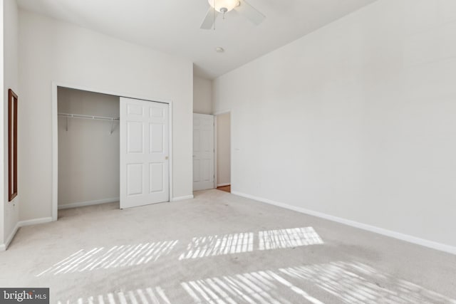 unfurnished bedroom with carpet, a closet, baseboards, and a ceiling fan