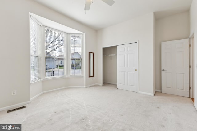 unfurnished bedroom featuring ceiling fan, a closet, visible vents, carpet flooring, and baseboards