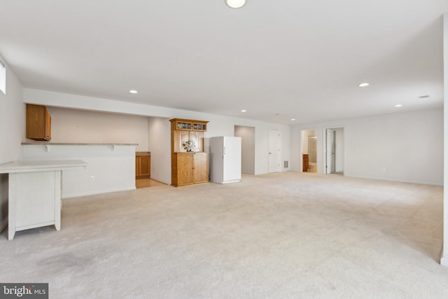 unfurnished living room featuring baseboards, recessed lighting, and light carpet