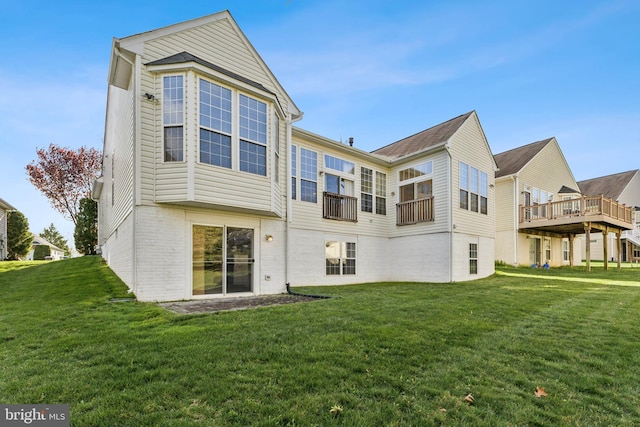 rear view of house featuring brick siding and a yard