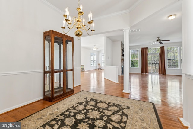 interior space with ornate columns, visible vents, ceiling fan with notable chandelier, and wood finished floors