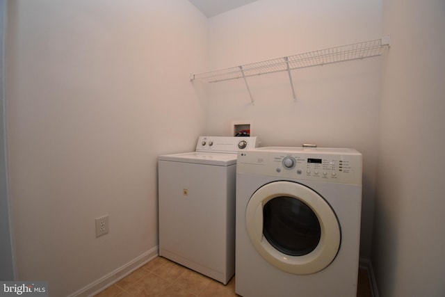 laundry room with washer and clothes dryer and baseboards