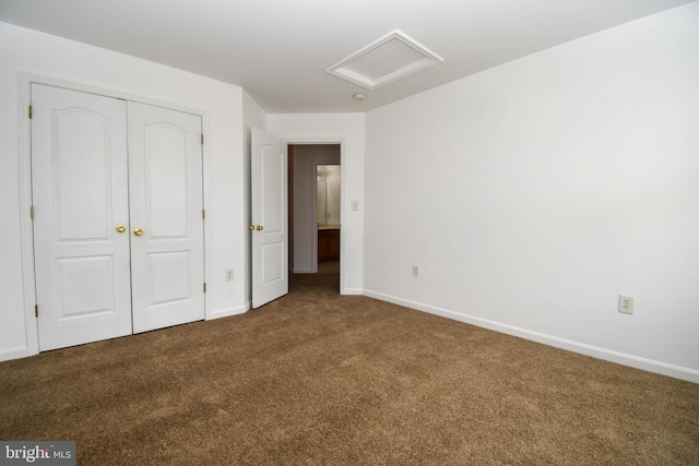 unfurnished bedroom featuring attic access, carpet, baseboards, and a closet