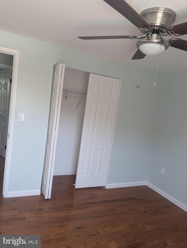 unfurnished bedroom with wood finished floors, a closet, baseboards, and ceiling fan