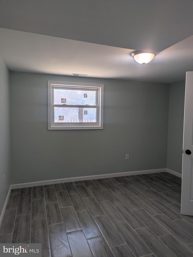 spare room with baseboards and wood tiled floor