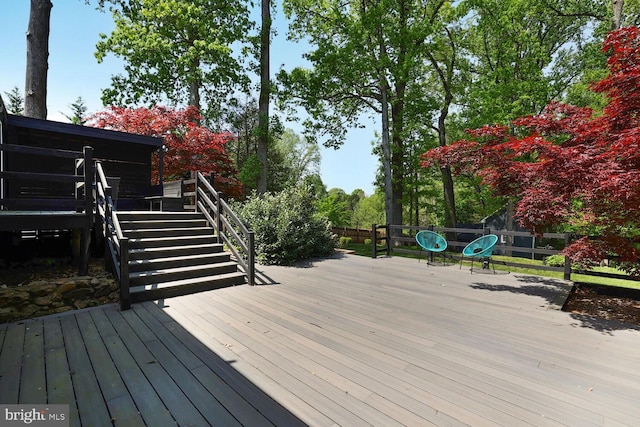 wooden terrace featuring stairs and fence
