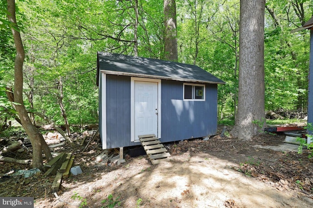 view of shed featuring a view of trees and entry steps