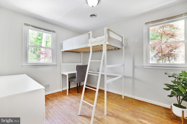 bedroom with baseboards, visible vents, and light wood-style flooring