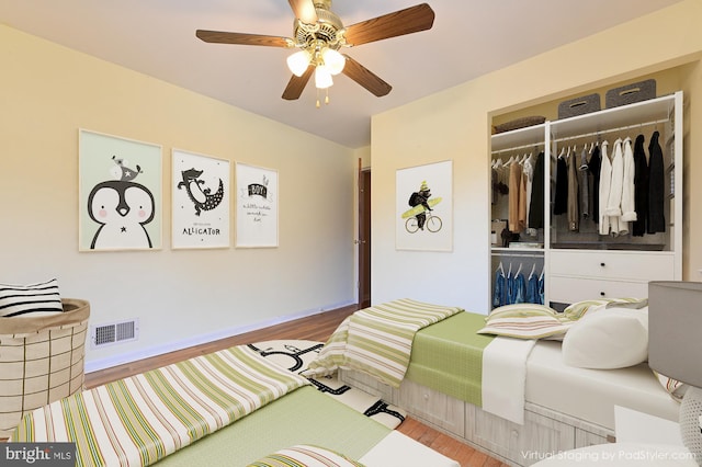 bedroom featuring wood finished floors, a closet, ceiling fan, and visible vents