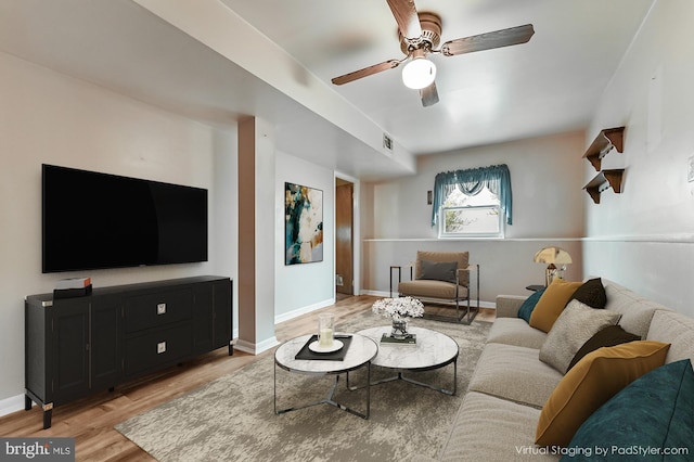 living room with baseboards, a ceiling fan, visible vents, and light wood-style floors
