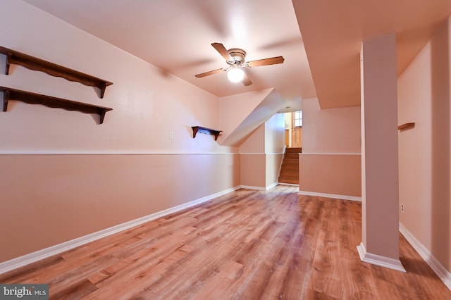 additional living space featuring baseboards, a ceiling fan, wood finished floors, and stairway