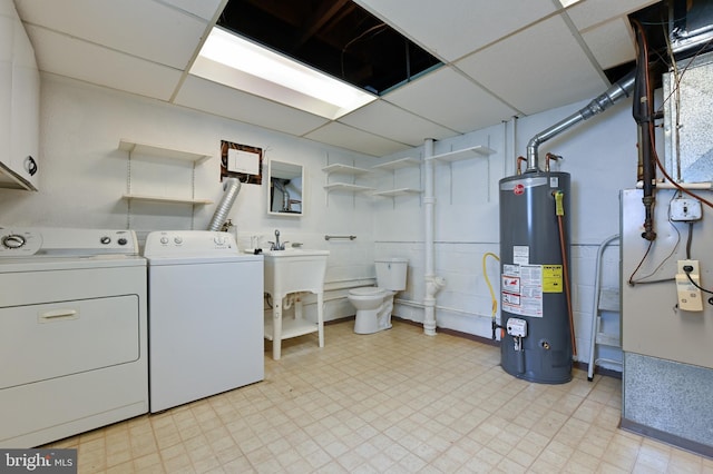 washroom featuring water heater, washing machine and clothes dryer, and light floors