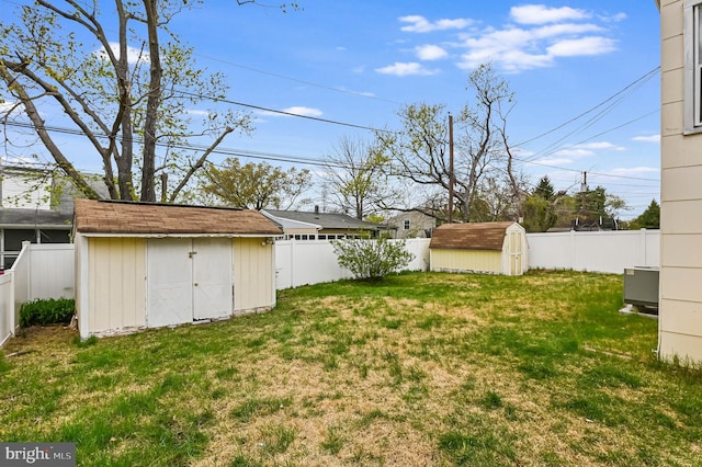 view of yard with an outbuilding, a shed, and a fenced backyard