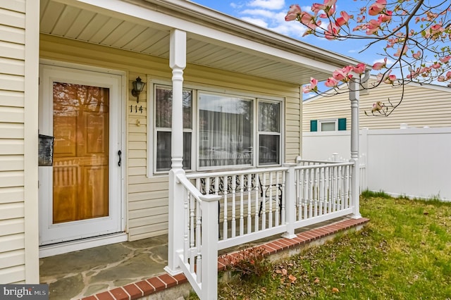 property entrance featuring a porch and fence