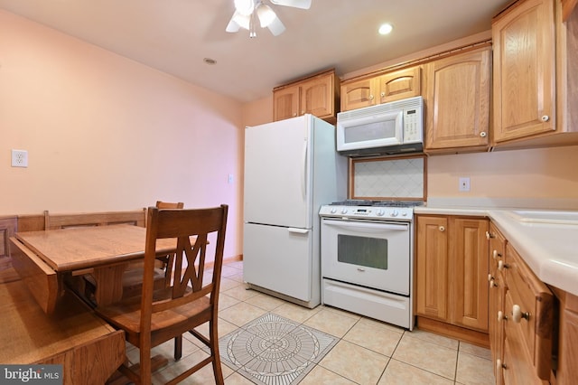 kitchen featuring light brown cabinets, white appliances, light tile patterned floors, light countertops, and a ceiling fan