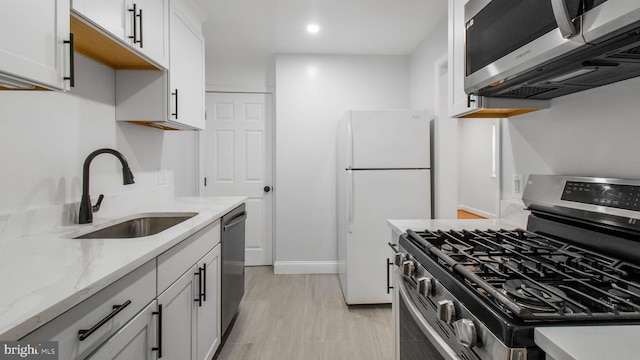 5011 37th Ave, Hyattsville, MD 20782 - kitchen featuring white cabinets, baseboards, a sink, appliances with stainless steel finishes, and light stone countertops