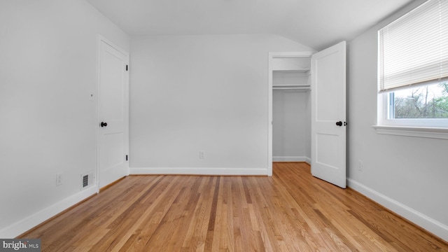 5011 37th Ave, Hyattsville, MD 20782 - unfurnished bedroom with a closet, baseboards, a walk in closet, lofted ceiling, and light wood finished floors