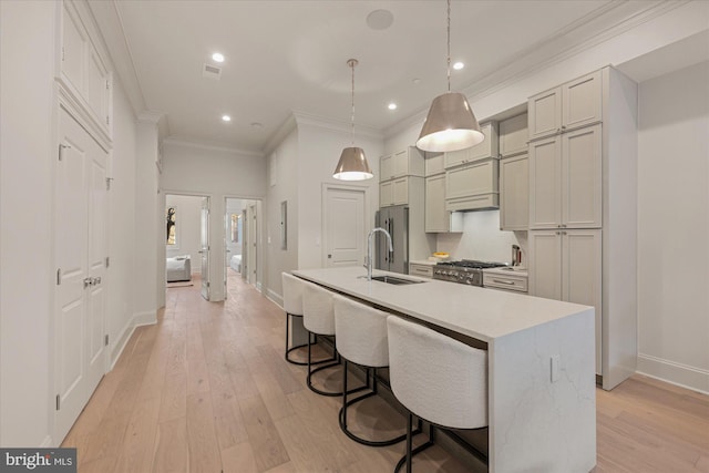 1335 11th St NW Unit 204, Washington, DC 20001 - kitchen with light countertops, a breakfast bar, ornamental molding, an island with sink, and a sink