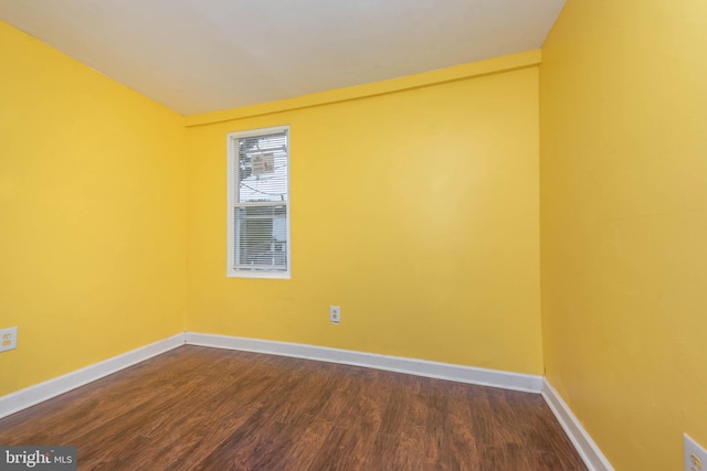 unfurnished room featuring dark wood-style floors and baseboards