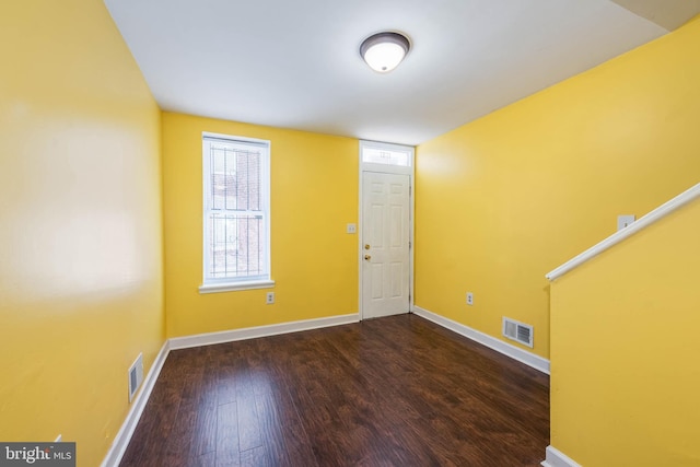 empty room featuring baseboards, visible vents, and wood finished floors
