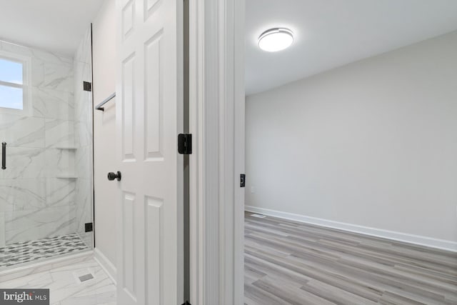 full bath with baseboards and a marble finish shower