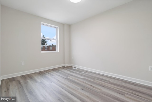 unfurnished room with baseboards and light wood-style flooring