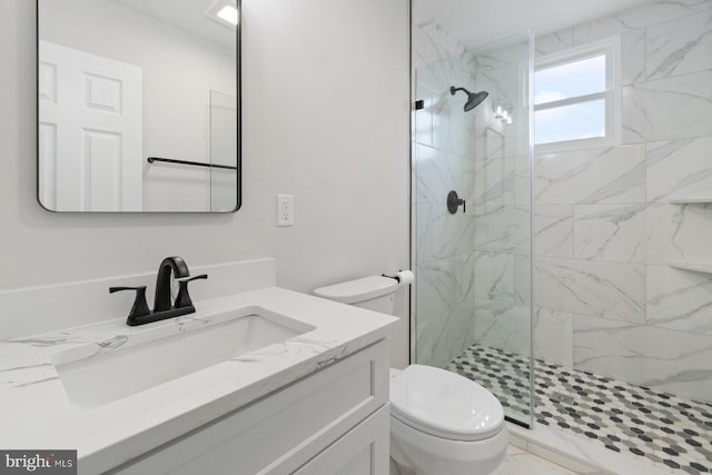 full bath featuring a marble finish shower, vanity, and toilet