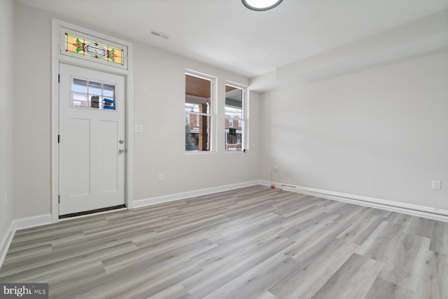 entryway featuring baseboards, plenty of natural light, light wood-style flooring, and visible vents