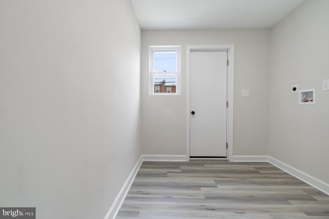 clothes washing area featuring laundry area, baseboards, light wood-type flooring, washer hookup, and hookup for an electric dryer
