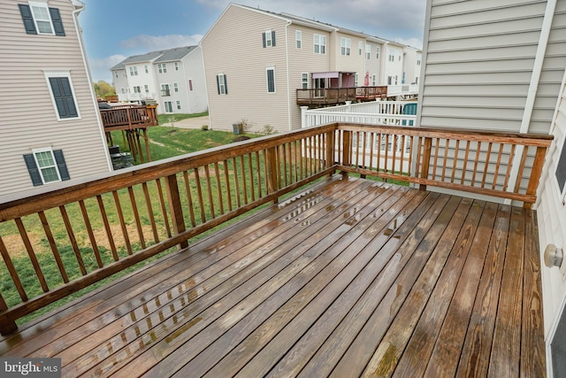 wooden terrace featuring a residential view and a lawn