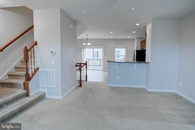 unfurnished living room with light carpet, recessed lighting, visible vents, and baseboards