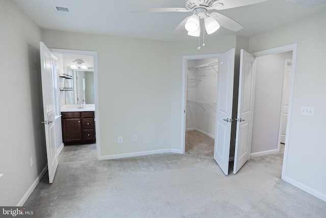 unfurnished bedroom featuring light carpet, a sink, and visible vents