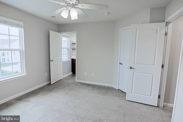 unfurnished bedroom with light colored carpet, baseboards, and visible vents