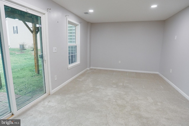 carpeted empty room featuring recessed lighting, visible vents, and baseboards