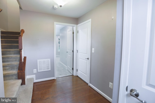 entrance foyer featuring wood finished floors, baseboards, visible vents, and stairway