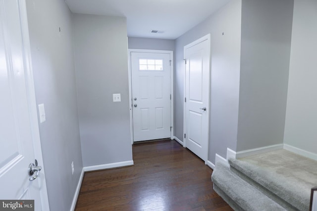 interior space featuring dark wood-type flooring, baseboards, and visible vents